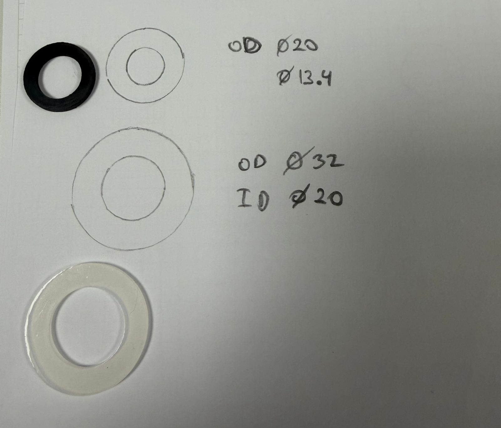 Hand-written dimensional analysis of annular parts beside technical diagrams